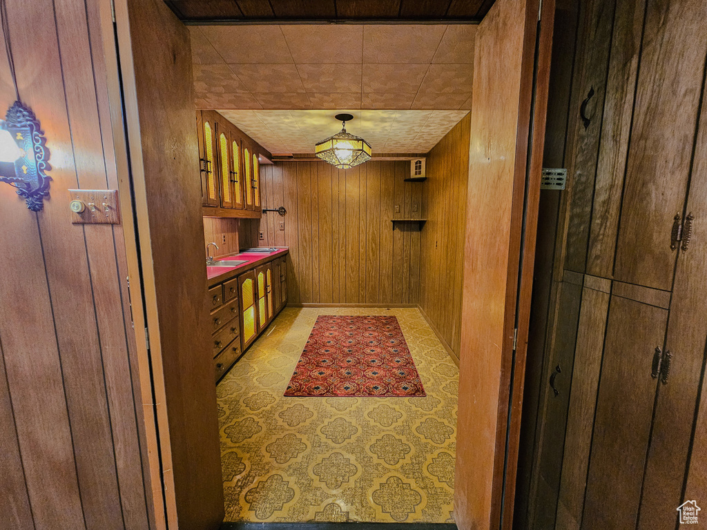 Hallway featuring wood walls and a sink
