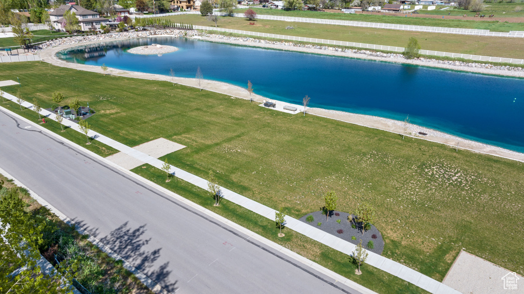 View of pool with a water view and a lawn