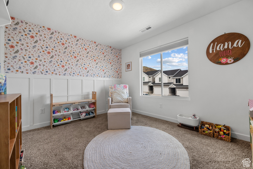Recreation room with wallpapered walls, a wainscoted wall, and carpet flooring