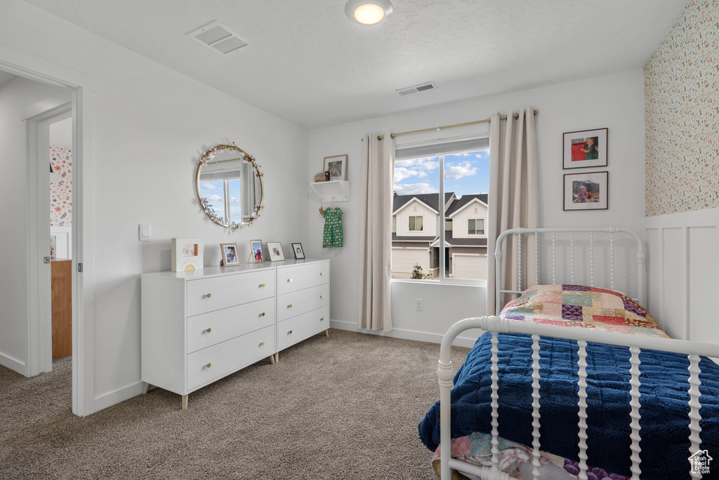 Carpeted bedroom featuring wainscoting and baseboards