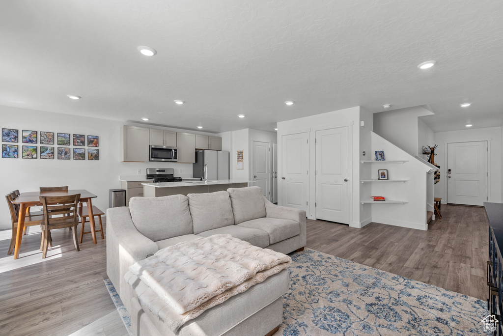 Living room featuring light wood-style flooring, recessed lighting, and baseboards