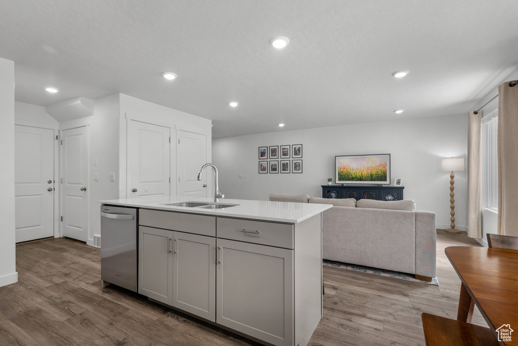 Kitchen featuring a sink, dishwasher, gray cabinets, wood finished floors, and recessed lighting