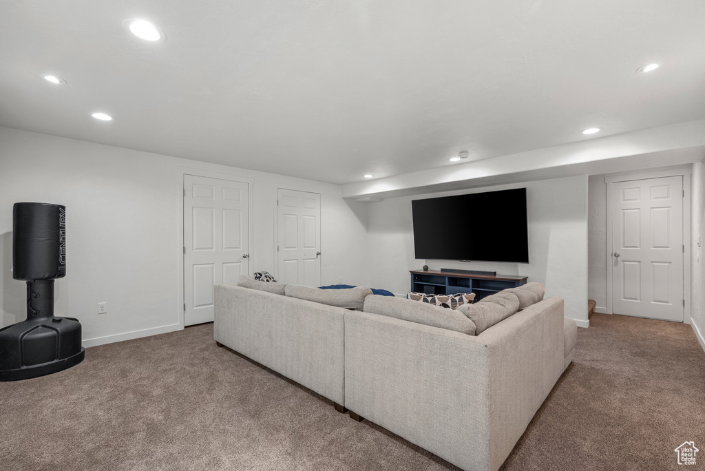 Living area with recessed lighting, light colored carpet, and baseboards