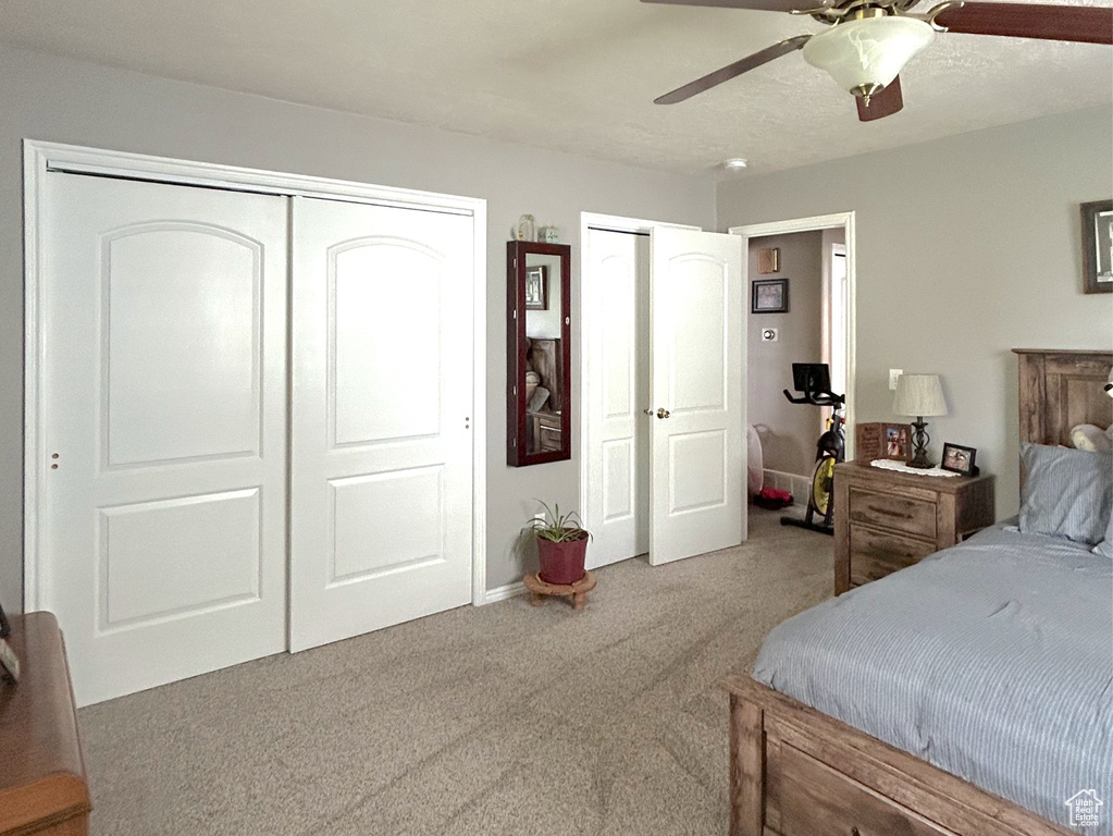 Bedroom featuring carpet flooring, multiple closets, and a ceiling fan