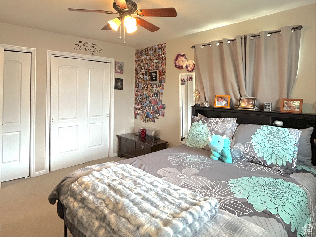 Carpeted bedroom with a ceiling fan