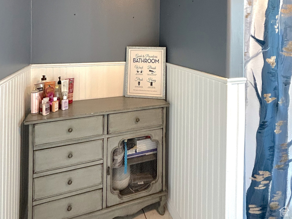 Full bathroom featuring a wainscoted wall, tile patterned flooring, and a textured ceiling