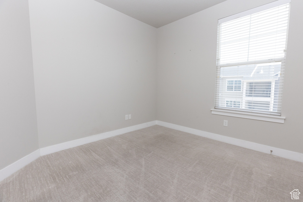 Carpeted spare room with baseboards