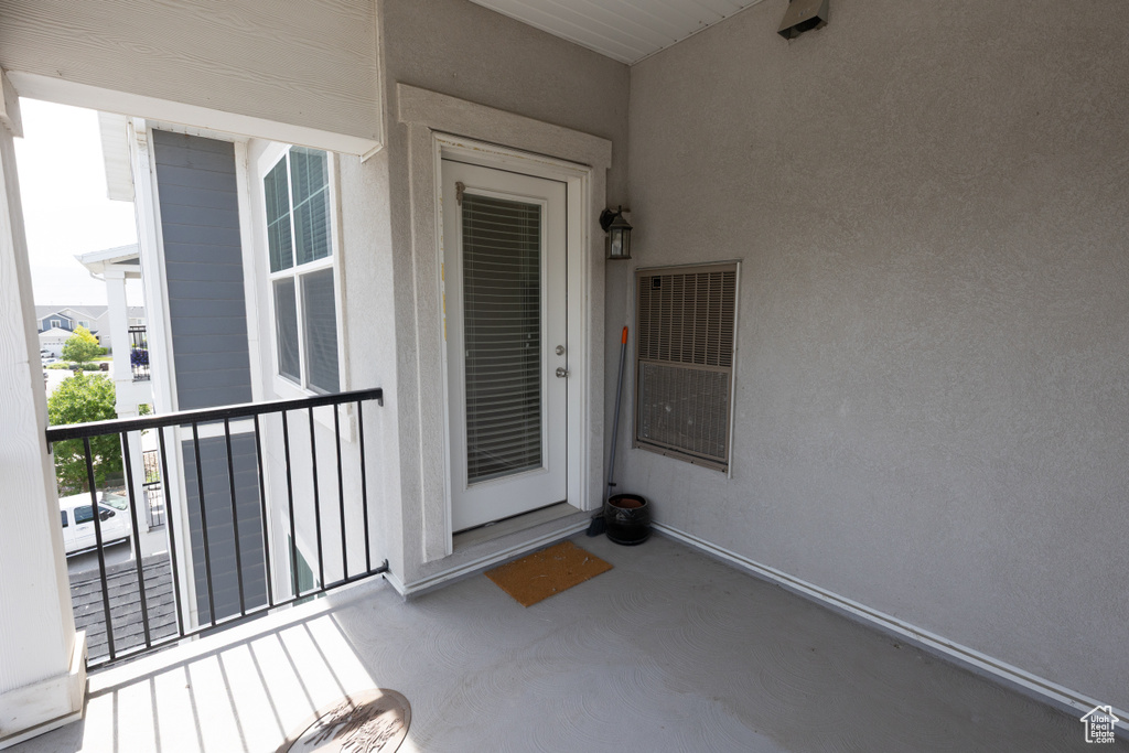 Property entrance featuring a balcony and stucco siding