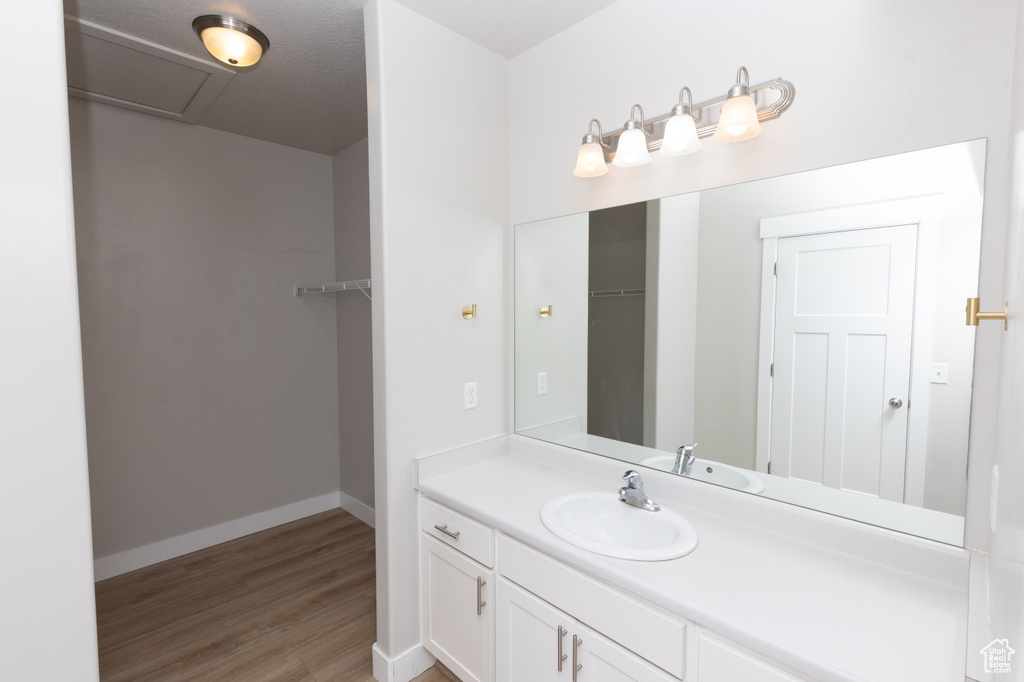 Bathroom with vanity, wood finished floors, and baseboards