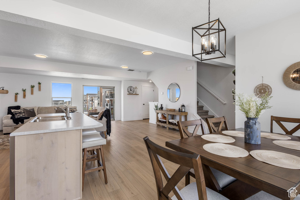 Dining area featuring light wood-style floors, stairway, recessed lighting, and a chandelier