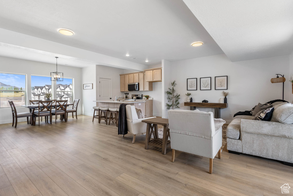 Living area featuring recessed lighting, light wood-style floors, and a chandelier