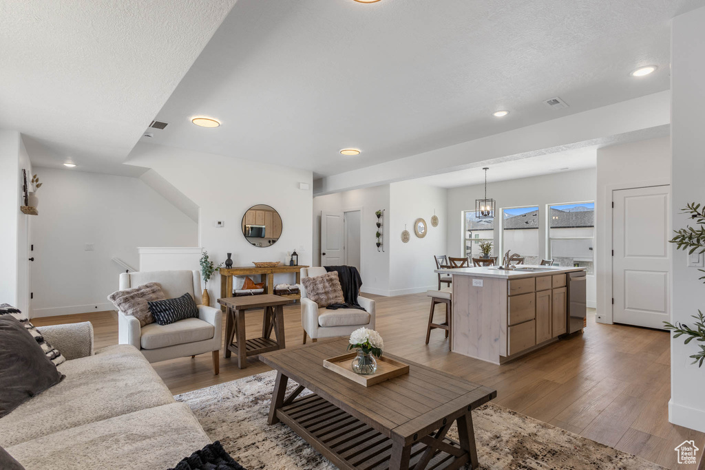 Living room featuring recessed lighting, light wood-style flooring, and baseboards