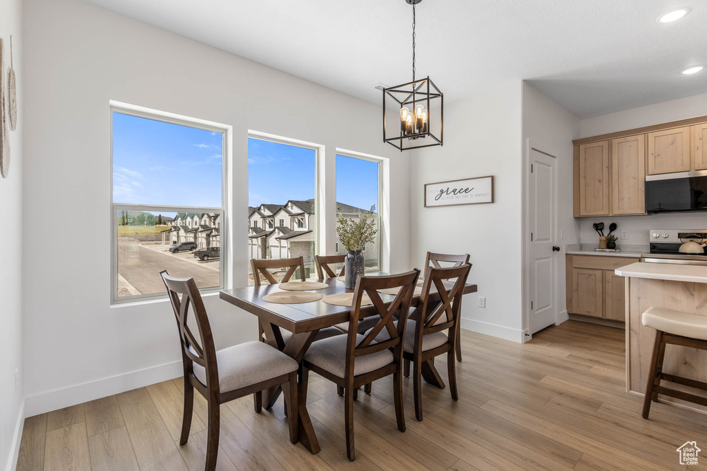 Dining room with baseboards, a chandelier, healthy amount of natural light, and recessed lighting