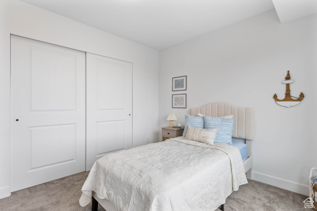 Bedroom with carpet, a closet, and baseboards