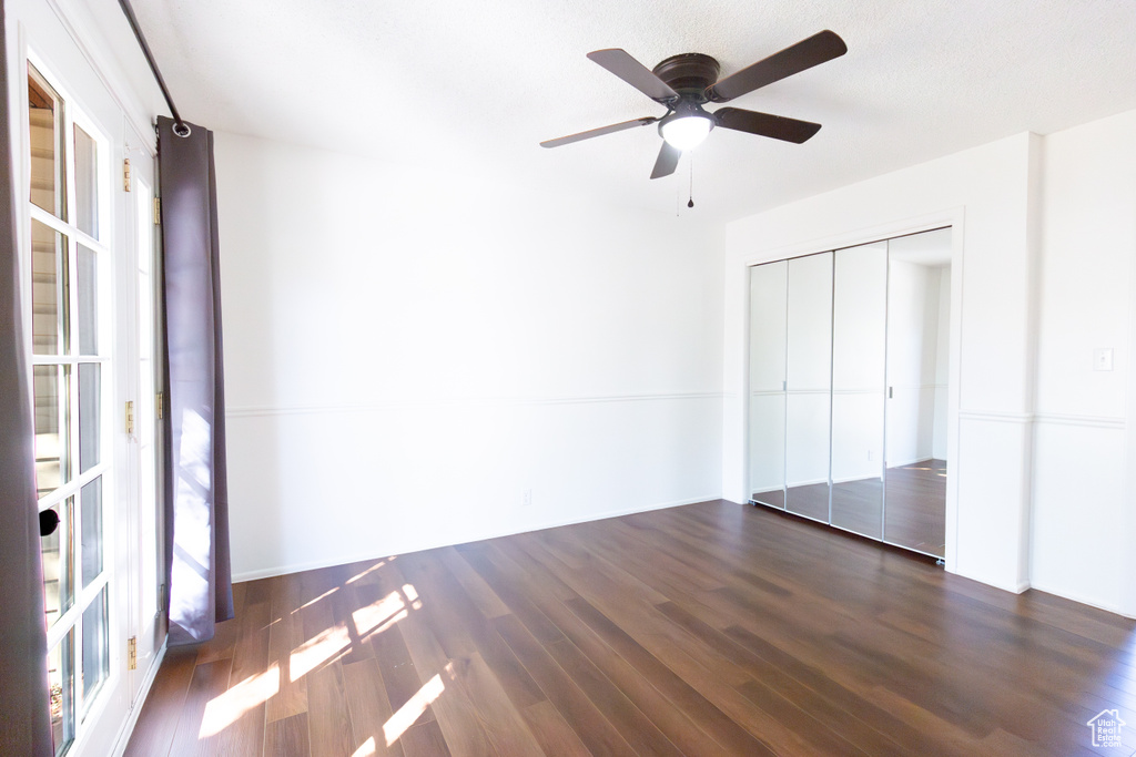 Unfurnished bedroom featuring wood finished floors, a closet, and ceiling fan