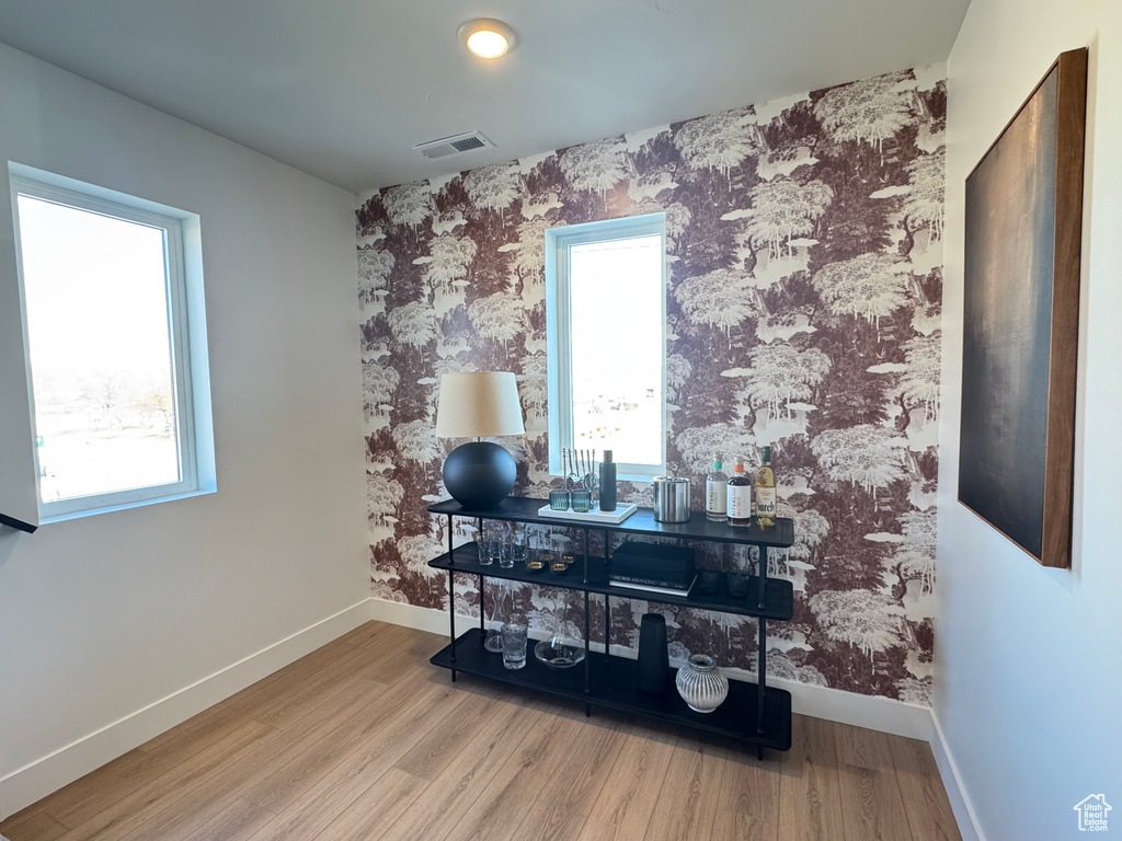 Misc room with wood finished floors, baseboards, and wallpapered walls