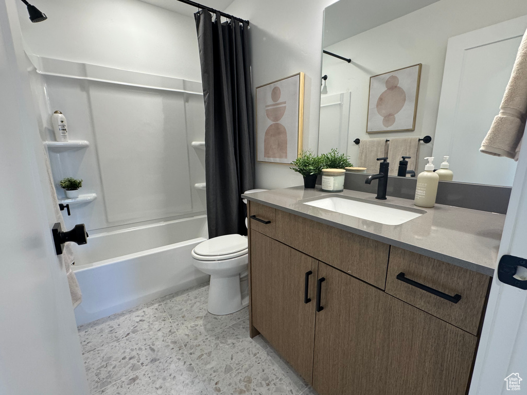 Bathroom featuring vanity, shower / tub combo, and toilet