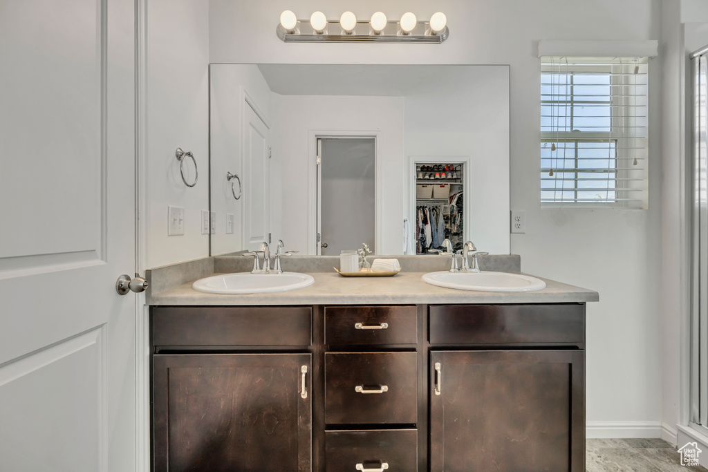Bathroom with double vanity and a spacious closet
