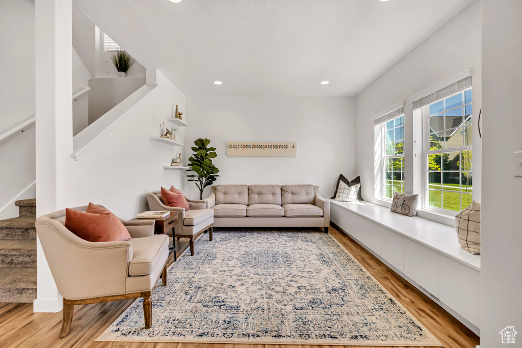 Living area with light wood-style floors, recessed lighting, and stairs