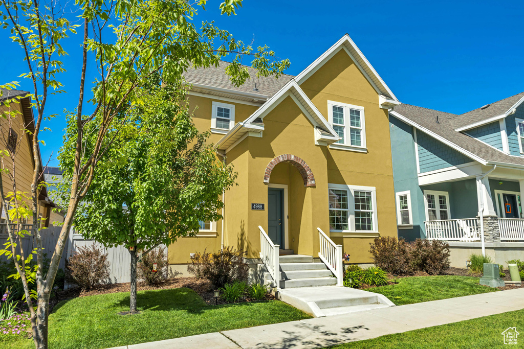 View of front of property with stucco siding and a front yard