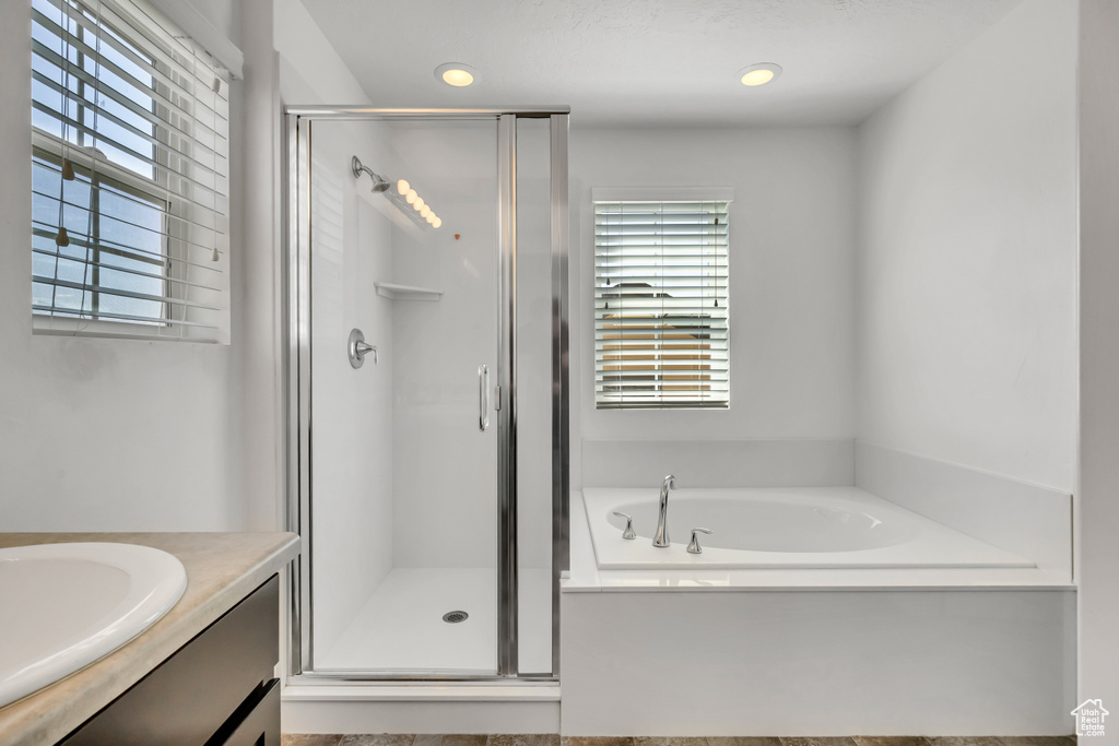 Full bath featuring a shower stall, a garden tub, vanity, and recessed lighting