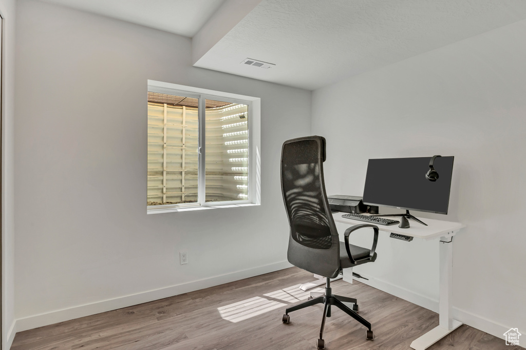 Home office with baseboards and wood finished floors