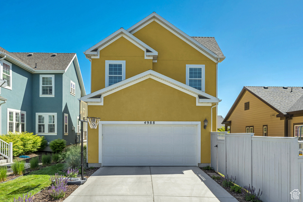 Traditional-style home featuring stucco siding and driveway