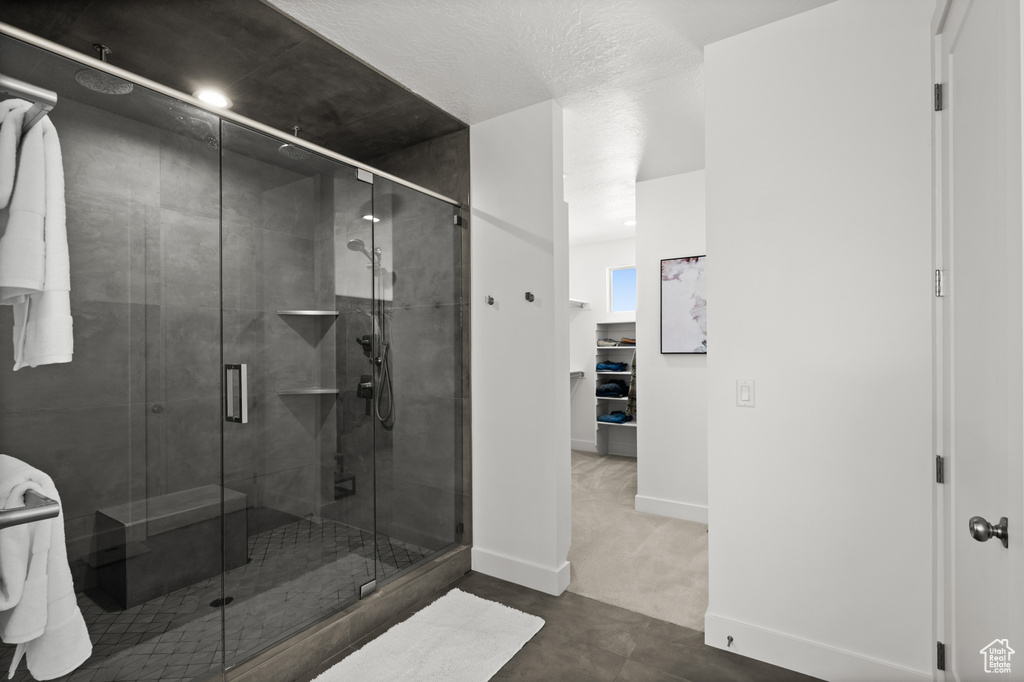 Full bath with a stall shower and baseboards