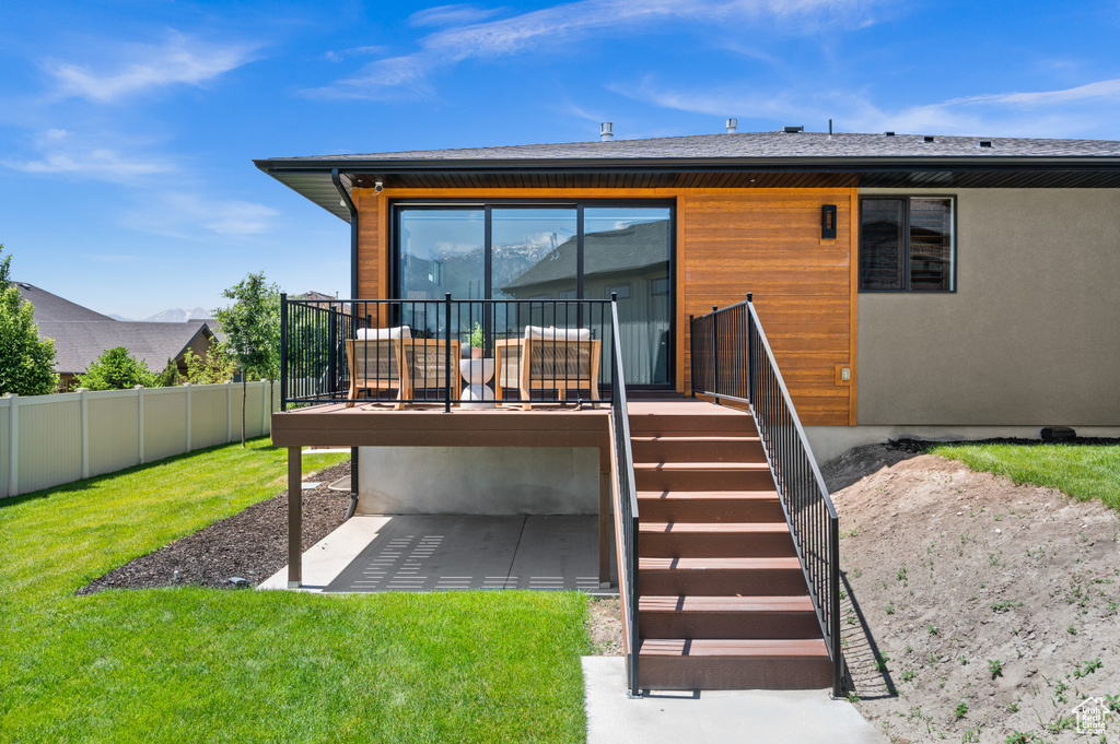 Rear view of property with a wooden deck and a patio