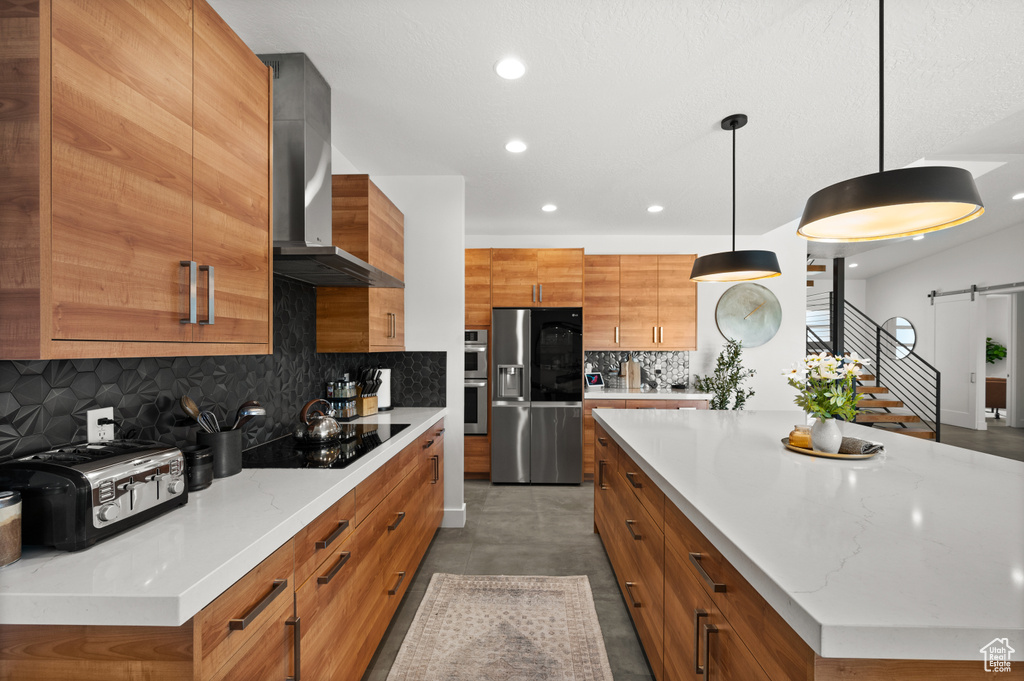 Kitchen with wall chimney range hood, stainless steel appliances, brown cabinets, recessed lighting, and backsplash