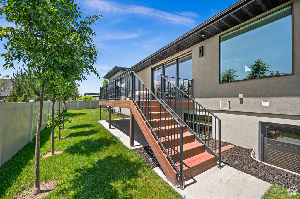 View of exterior entry with stucco siding and a wooden deck