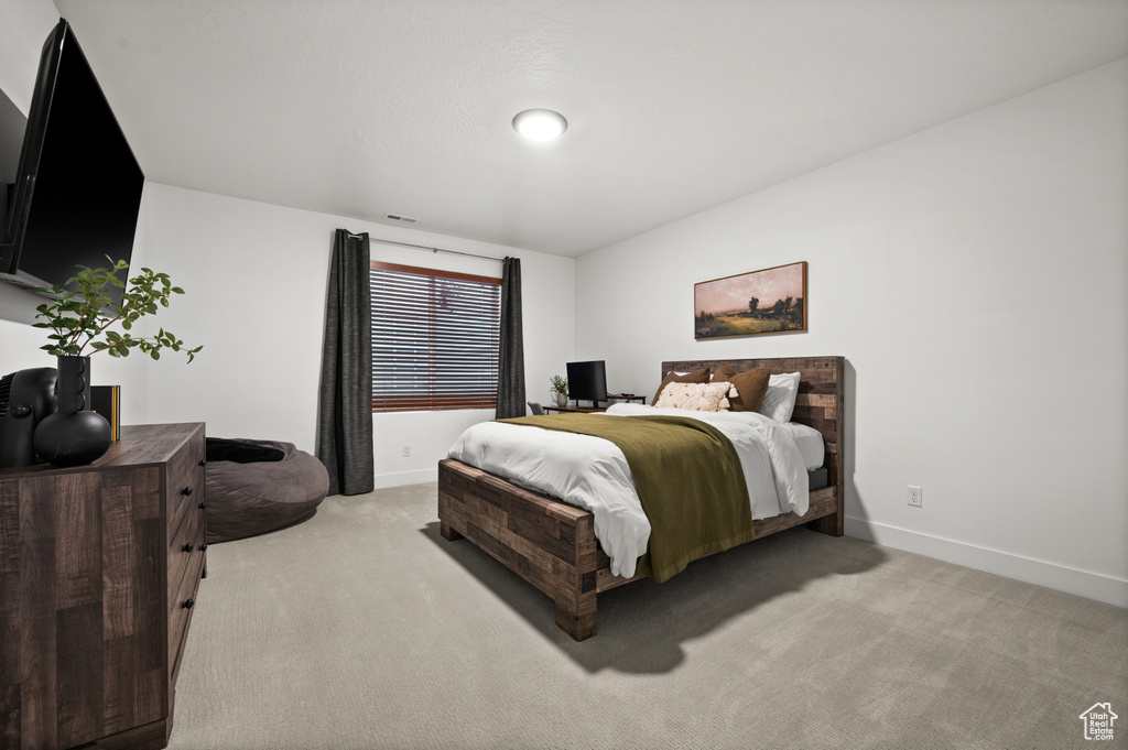 Bedroom featuring light carpet and baseboards