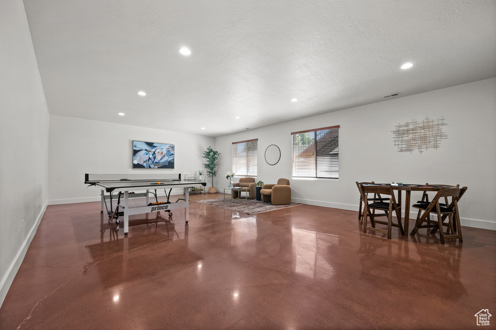 Dining area featuring finished concrete flooring, baseboards, and recessed lighting