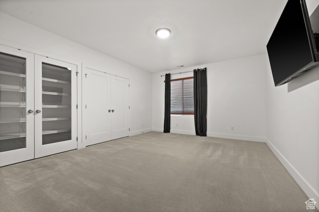 Unfurnished bedroom featuring two closets, light colored carpet, and baseboards