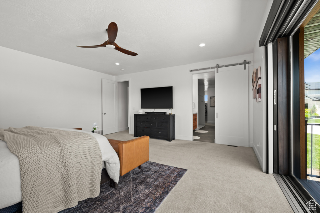 Bedroom featuring a barn door, light colored carpet, recessed lighting, ceiling fan, and baseboards