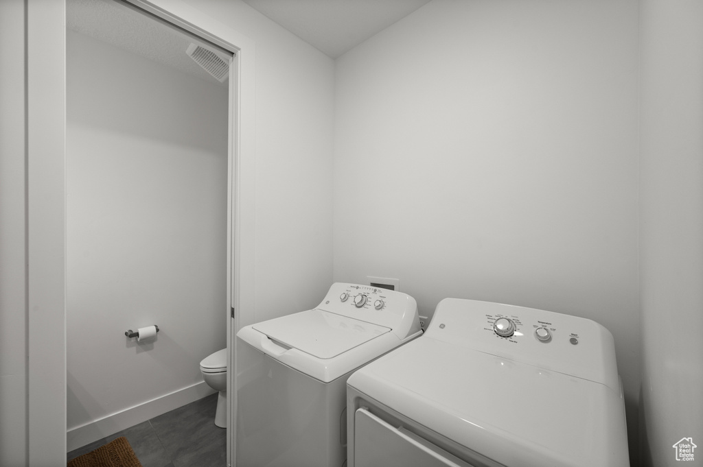 Laundry room featuring washing machine and clothes dryer and baseboards