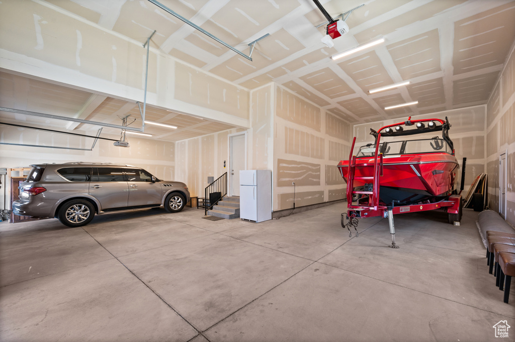 Garage with freestanding refrigerator and a garage door opener