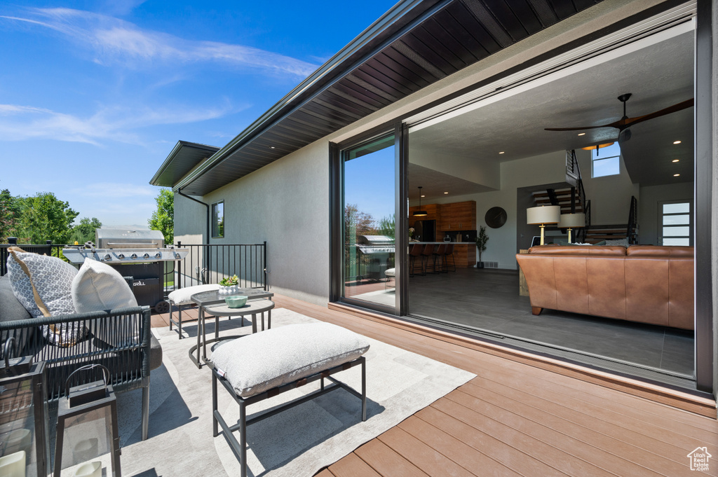 Wooden deck with an outdoor hangout area and a ceiling fan