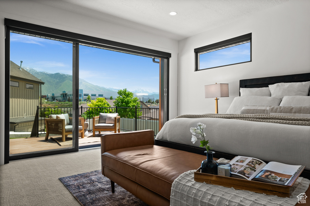 Bedroom with a mountain view, access to exterior, carpet flooring, and recessed lighting