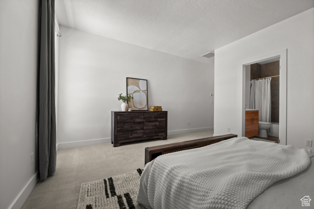 Bedroom featuring carpet floors, baseboards, and a textured ceiling