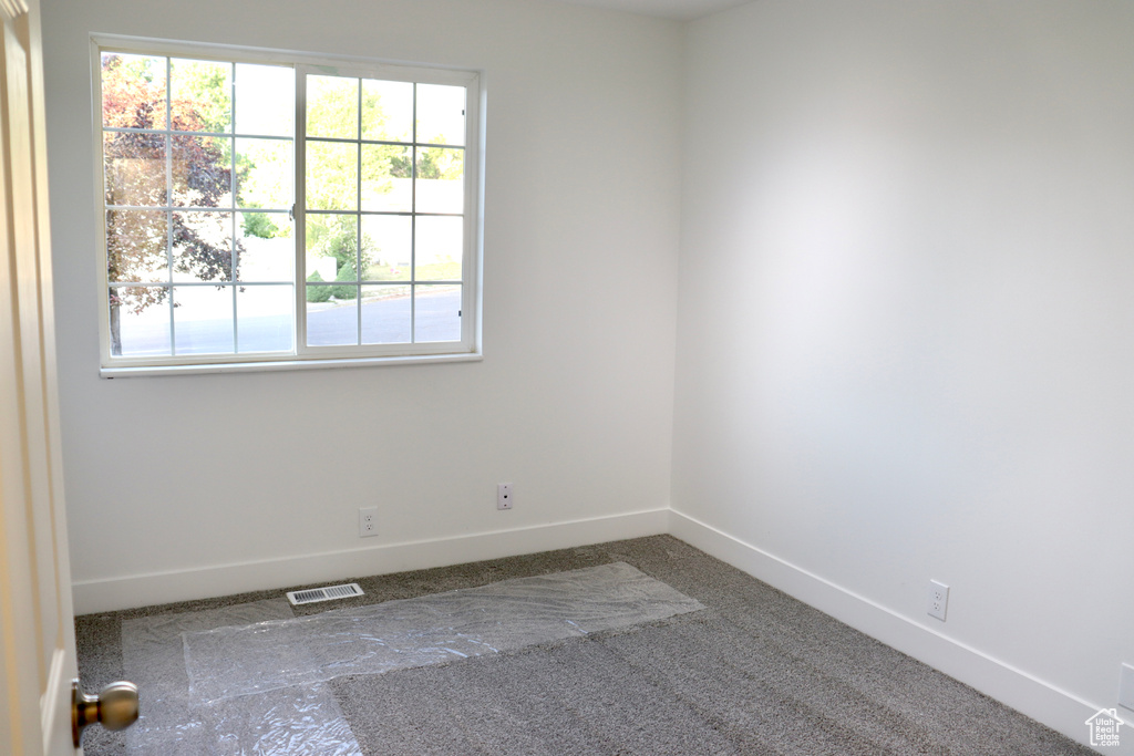 Spare room featuring baseboards and carpet flooring