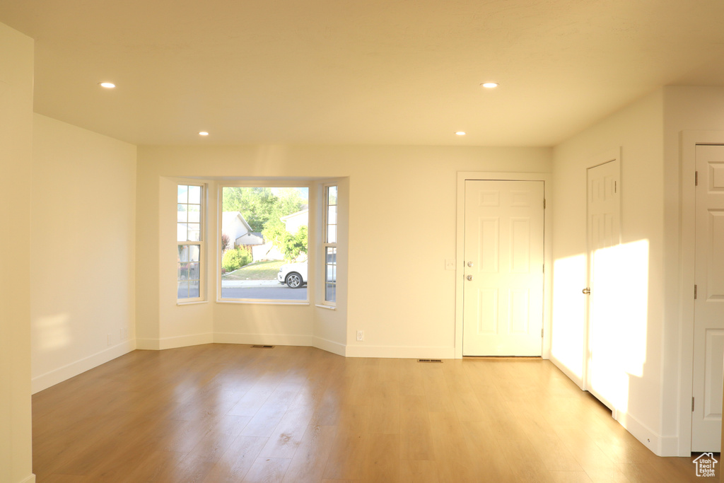 Unfurnished room with recessed lighting, light wood-type flooring, and baseboards