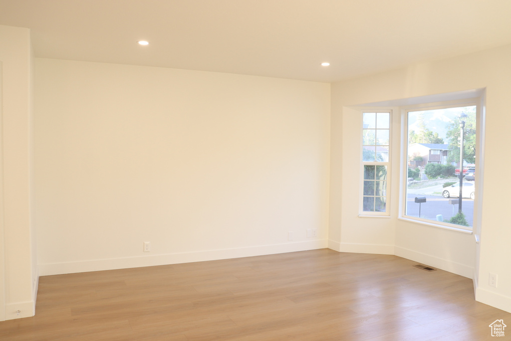 Unfurnished room with light wood-style flooring, baseboards, and recessed lighting