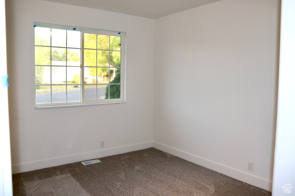 Empty room with dark carpet and baseboards