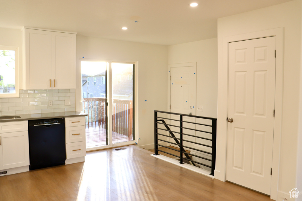 Kitchen with dishwasher, white cabinetry, light wood finished floors, recessed lighting, and decorative backsplash