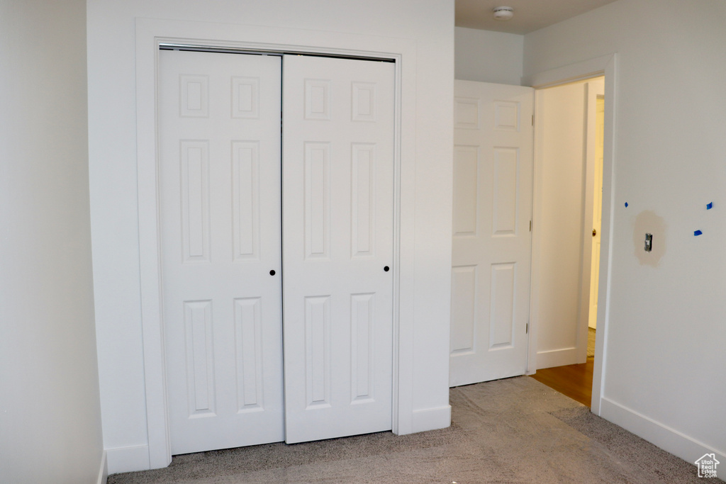 Unfurnished bedroom featuring carpet floors, a closet, and baseboards