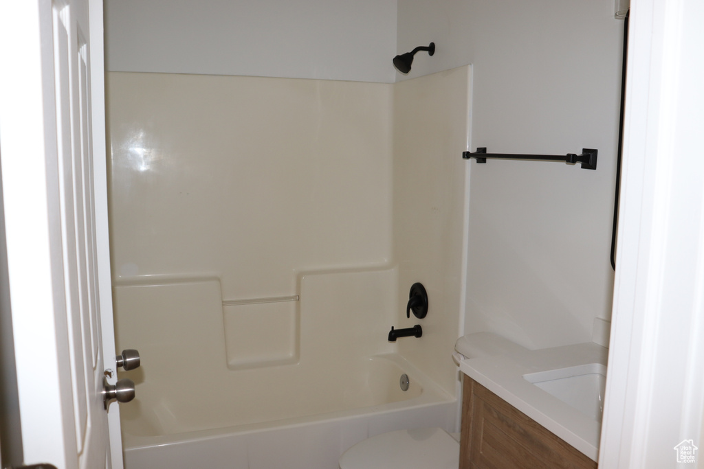 Full bathroom featuring toilet, vanity, and washtub / shower combination