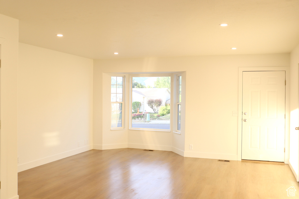 Spare room featuring recessed lighting, light wood finished floors, and baseboards