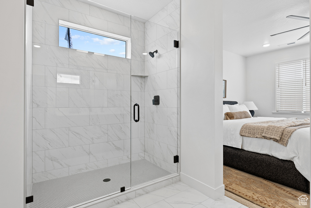 Full bath featuring ensuite bath, marble look tiles, a stall shower, and baseboards