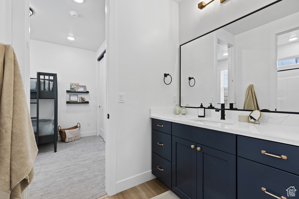 Bathroom with vanity, baseboards, and wood finished floors